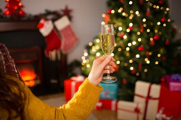 Pelirroja sosteniendo una copa de champán en el sofá en Navidad —  Fotos de Stock