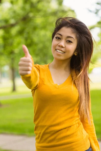 Женщина показывает пальцами вверх в парке — стоковое фото