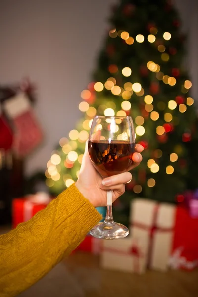 Žena sedí na gauči, zatímco drží sklenici červeného vína — Stock fotografie