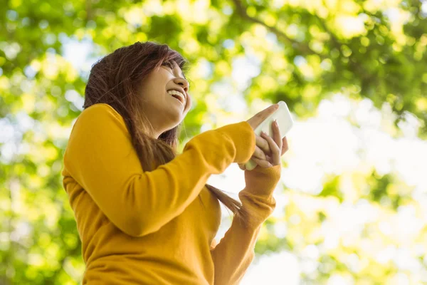 Woman text messaging in park — Stock Photo, Image