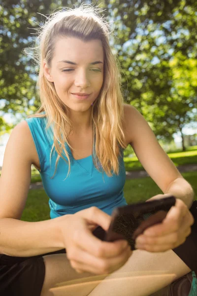 Passar blond textning på sin smartphone — Stockfoto