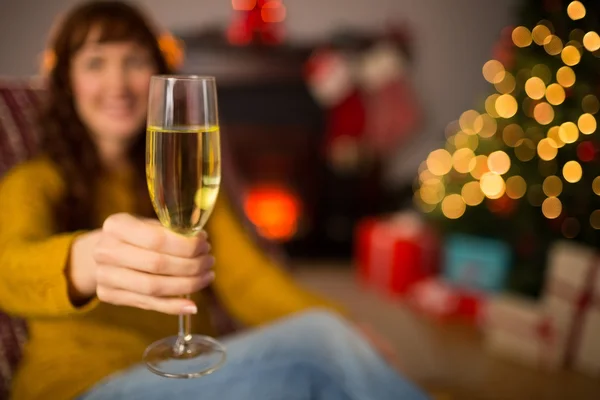 Rotschopf hält zu Weihnachten Glas Champagner auf Couch — Stockfoto