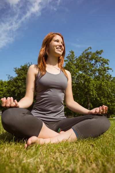 Portrait of a pretty redhead relaxing in lotus pose — Stock Photo, Image
