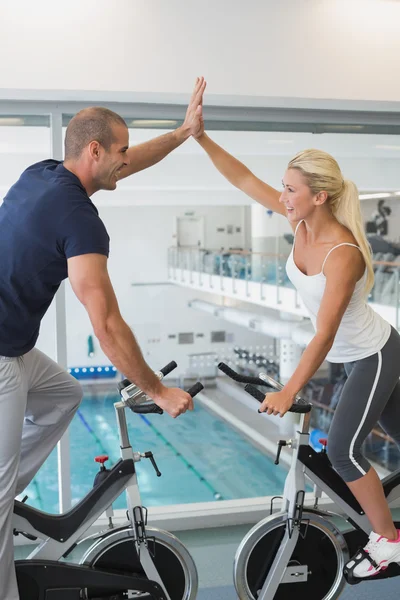 Paar gibt High Five auf dem Heimtrainer — Stockfoto