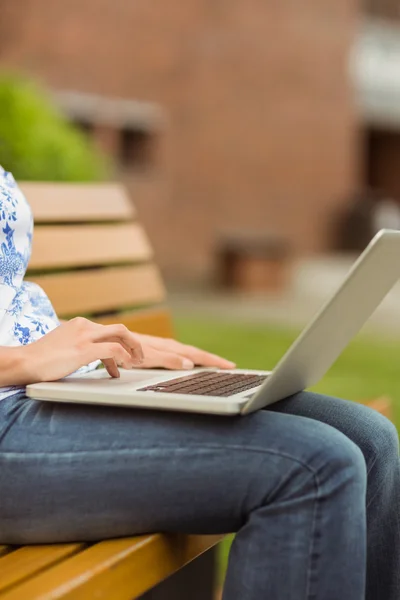 Γυναίκα που κάθεται στον πάγκο χρησιμοποιώντας το φορητό υπολογιστή — Φωτογραφία Αρχείου