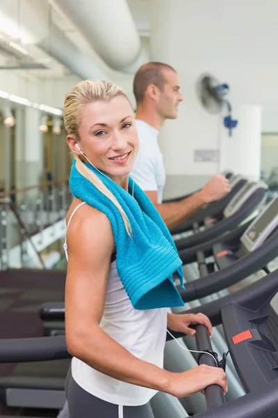 Fit young couple running on treadmills at gym — Stock Photo, Image