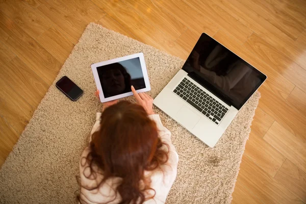 Mujer bonita acostada en el suelo usando tecnología en Chritmas — Foto de Stock