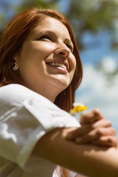 Retrato de una bonita pelirroja sosteniendo flores — Foto de Stock