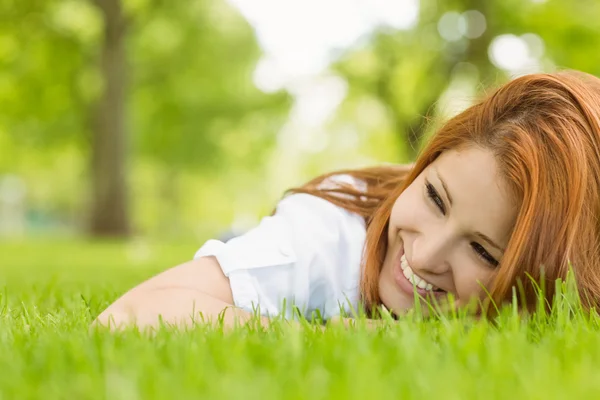 Retrato de una pelirroja bonita sonriendo y mintiendo — Foto de Stock