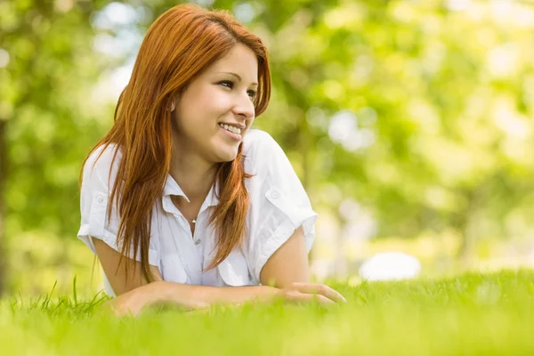 Portrait of a pretty redhead smiling and lying — Stock Photo, Image