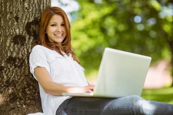 Mooie roodharige zit met haar laptop — Stockfoto