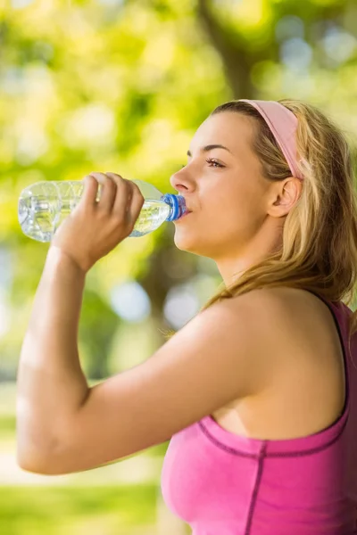 Fit blonde appuyé contre l'eau potable de l'arbre — Photo