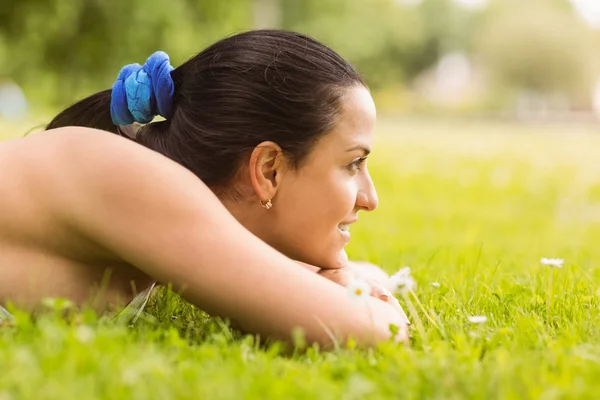 Gelukkig fit brunette liggen op het gras — Stockfoto