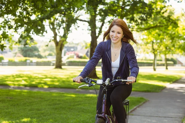 Pretty redhead cycling a bike — Stock Photo, Image