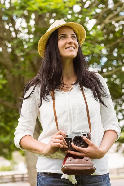 Sonriente morena sosteniendo a la antigua cámara — Foto de Stock