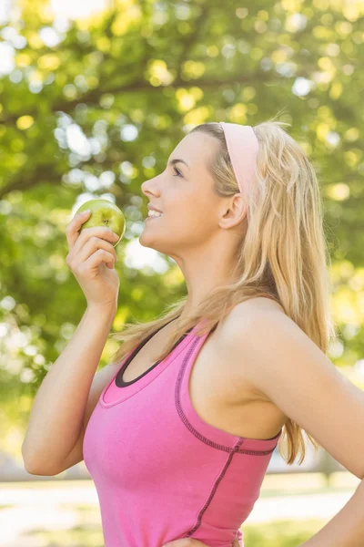 Vältränad blondin innehar grönt äpple — Stockfoto