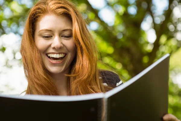 Vrouwelijke student leesboek in park — Stockfoto