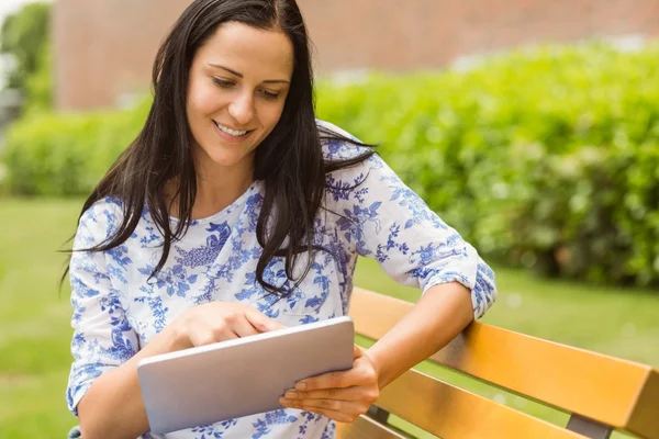 Lächelnde Brünette, die ihr Tablet berührt — Stockfoto