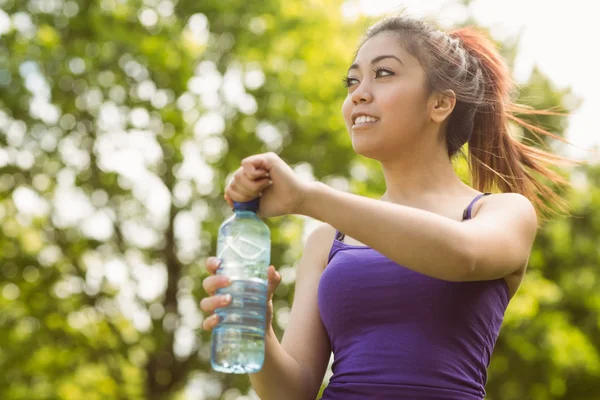 Mujer sosteniendo botella de agua en el parque — Foto de Stock