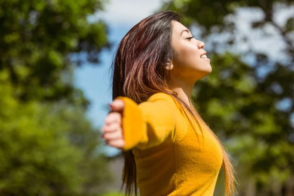 Vrouw met armen gestrekt in park — Stockfoto