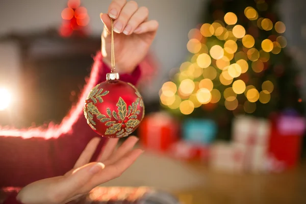 Mujer en puente sosteniendo bauble rojo — Foto de Stock