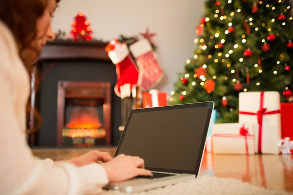 Redhead woman lying on floor using laptop at christmas — Stock Photo, Image