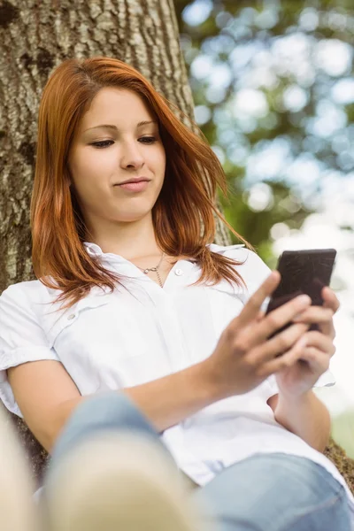 Mooie roodharige voor SMS-berichten op haar telefoon — Stockfoto