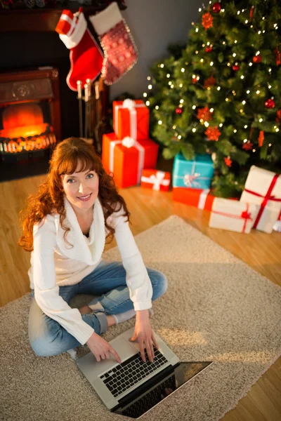 Mulher ruiva sentada no chão usando laptop no Natal — Fotografia de Stock