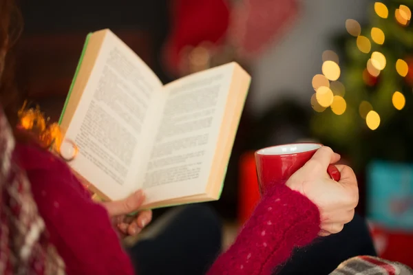 Woman in jumper reading and drinking coffee — Stock Photo, Image