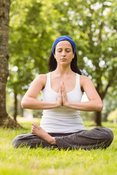 Fit Brünette sitzt in Lotus-Pose mit Händen zusammen — Stockfoto