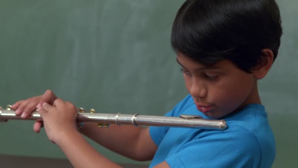 Lindo alumno tocando la flauta en el aula — Vídeo de stock