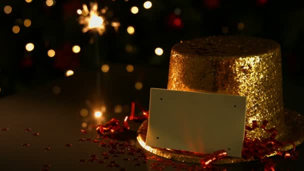 Sparkler accanto a un cappello d'oro e una carta — Video Stock