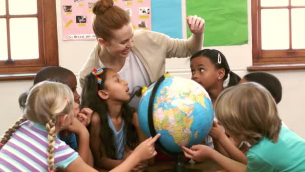 Lindos alumnos y profesor en el aula con globo — Vídeos de Stock