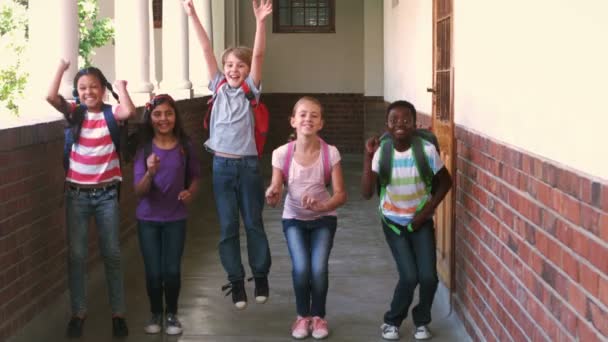 Glückliche Schüler springen in der Luft in einem Flur — Stockvideo