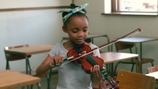 Cute pupil playing violin in classroom — Stock Video