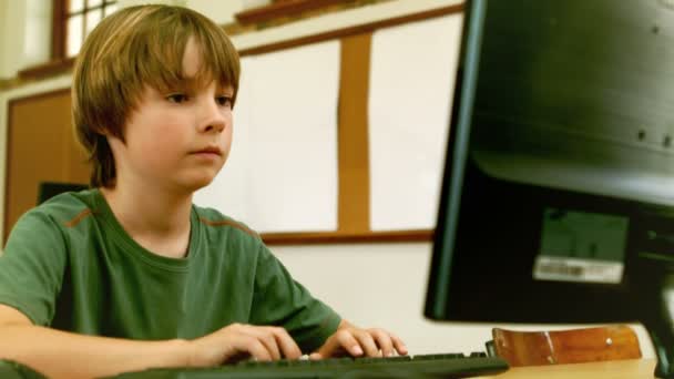 Lindo pequeño alumno mirando portátil en el aula — Vídeos de Stock