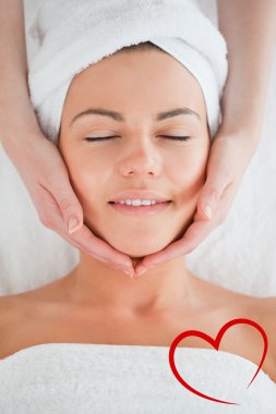 Smiling woman having a facial massage clipart