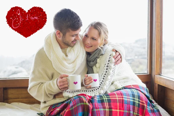 Verliefde paar in de winter dragen met cups agains — Stockfoto