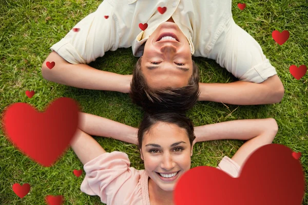 Two friends smiling while lying head to head — Stock Photo, Image