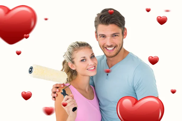 Couple hugging and holding paint roller — Stock Photo, Image
