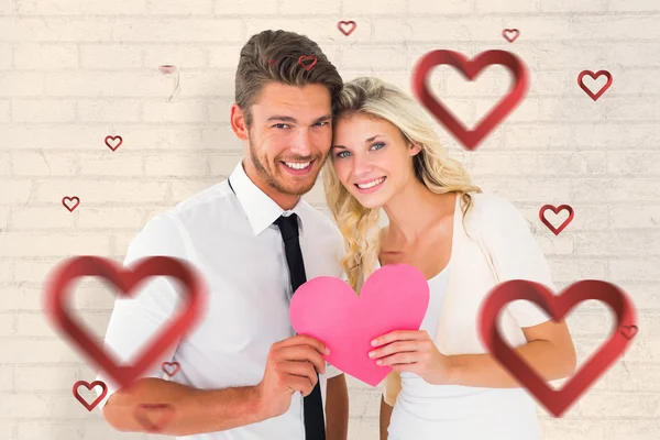 Attractive couple holding pink heart — Stock Photo, Image