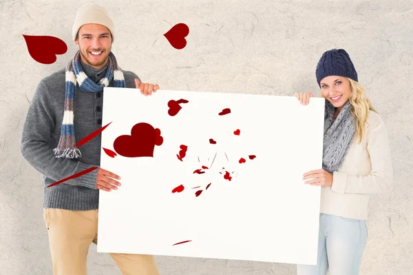 ポスターを示す冬ファッションのカップル — ストック写真