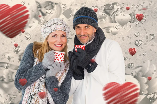 Szczęśliwa para w moda zima trzyma kubki — Zdjęcie stockowe