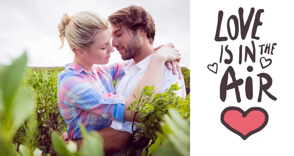 Smiling couple embracing outside among — Stock Photo, Image