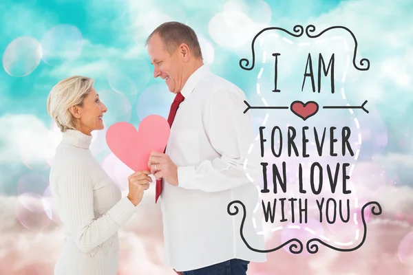 Older affectionate couple holding pink heart — Stock Photo, Image