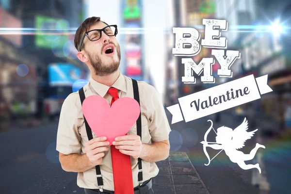 Composite image of geeky hipster crying and holding heart card — Stock Photo, Image