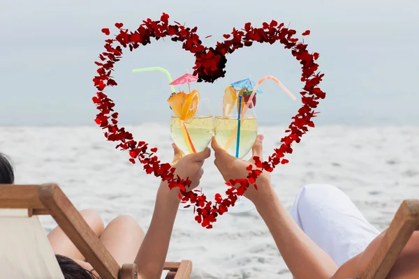 Paar klappert Cocktailgläser am Strand — Stockfoto