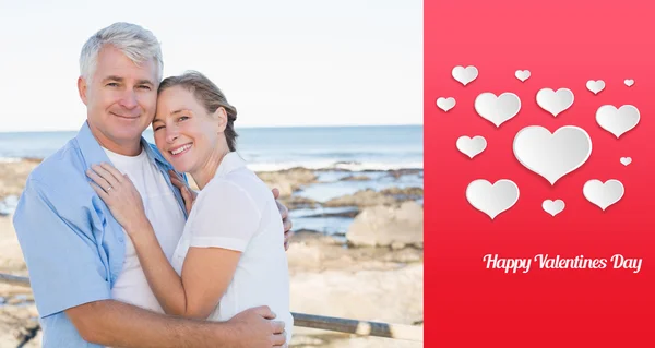 Happy casual couple embracing by the sea — Stock Photo, Image