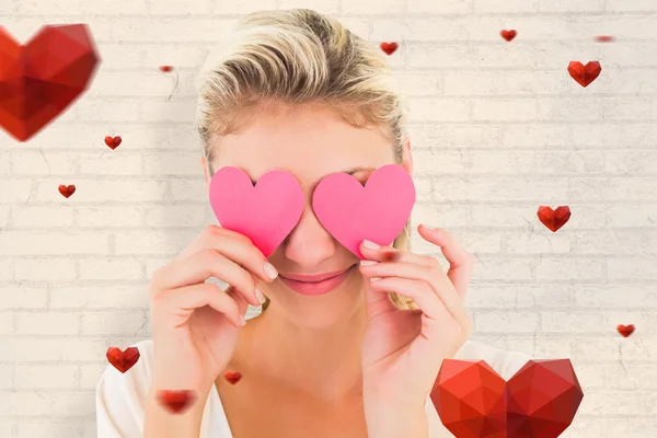 Attractive blonde holding hearts over eyes — Stock Photo, Image