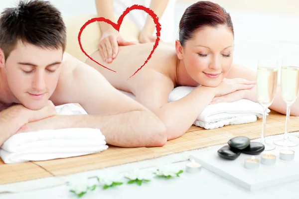 Composite image of charming young couple enjoying a back massage — Stock Photo, Image
